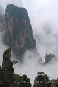 Photographed in early morning when trees on granite peaks appear in fog and clouds like a Chinese painting.
