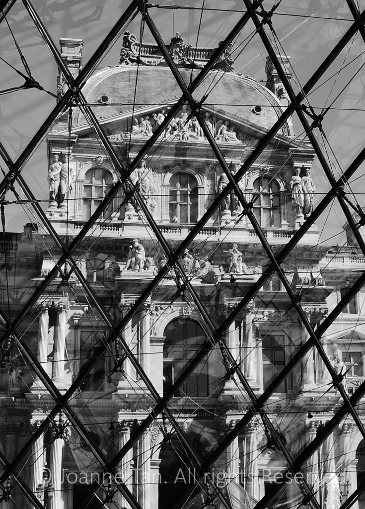 The old Louvre Palance viewed via glass and metal grids of the Glass Pyramid.