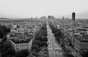Cityscape & streetscape of Paris, France, the city of light, from the top of the Arch of Triumph, along the tree-lined boulevard to the vanishing point of another modern arch in the horizon.