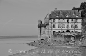 An old, regal, elegant French mansion by the water where sea meets the river, near Le Mont St. Michel, France.