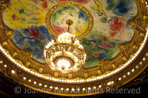 French artist, painter of 20th centuray Marc Chagall's mural atop of Grand Opera Houses. illuminated by a circle of jewel-like lights and a chandelier. Picture taken in Paris, France.